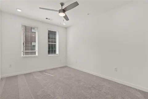 an empty room with windows and fan