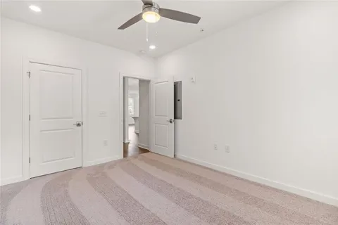 an empty room with a ceiling fan and closet area