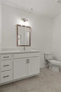 a bathroom with a sink vanity mirror and toilet