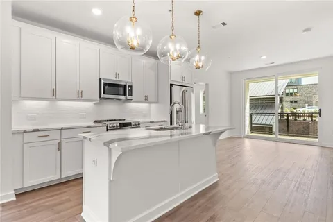 a kitchen with stainless steel appliances granite countertop a sink a stove and a refrigerator