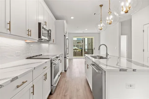a kitchen with stainless steel appliances a sink stove and cabinets