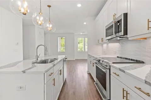 a kitchen with stainless steel appliances granite countertop a sink a stove and a microwave