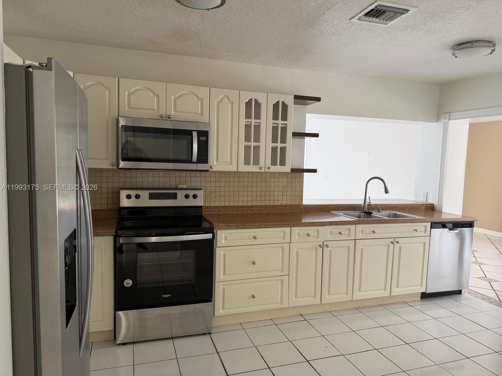 12695 Southwest 144th Terrace Miami, FL 33186 - Photo 3 of 43 a kitchen with white cabinets stainless steel appliances and a sink