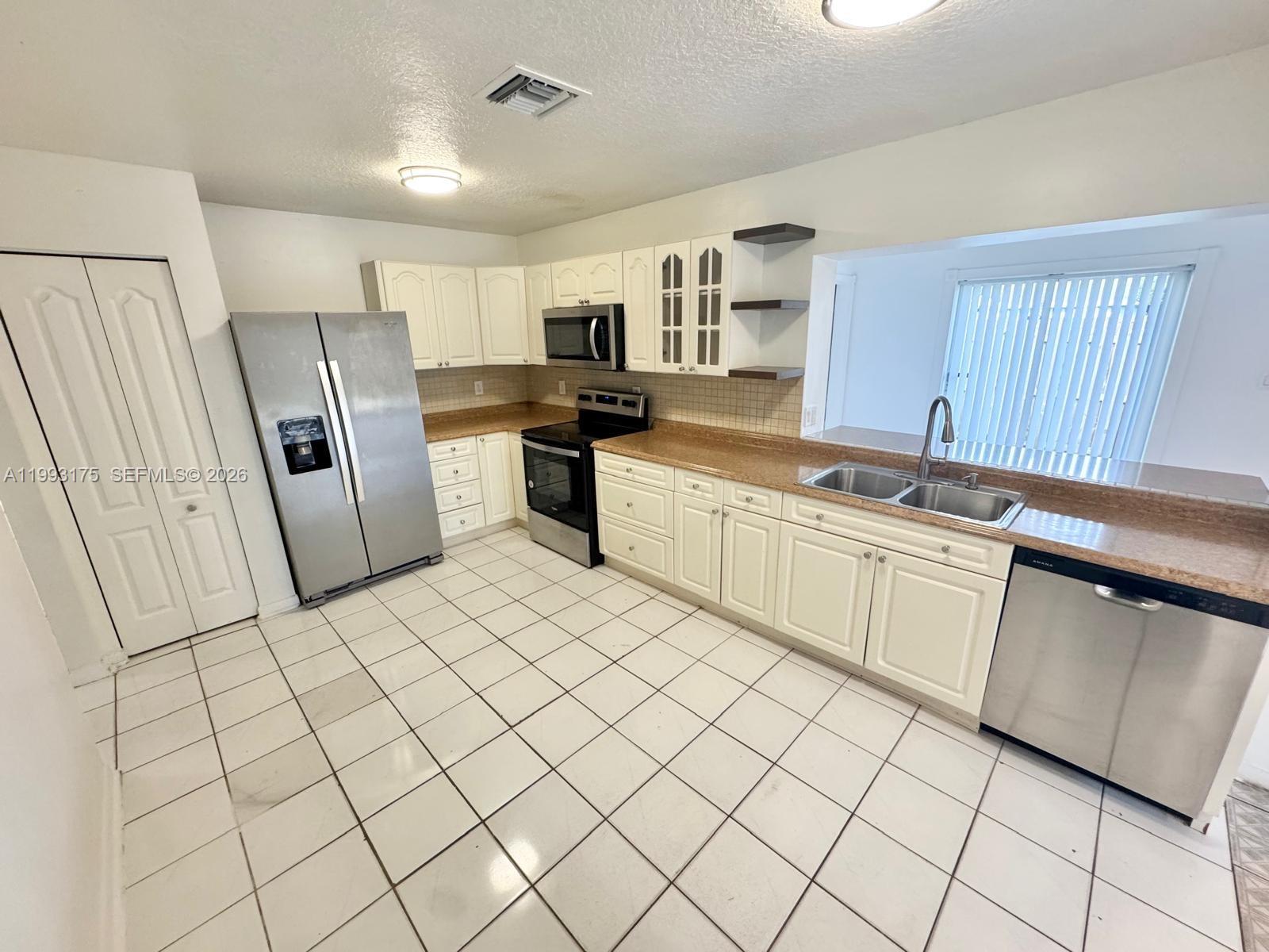 12695 Southwest 144th Terrace Miami, FL 33186 - Photo 38 of 43 a kitchen with white cabinets and white appliances