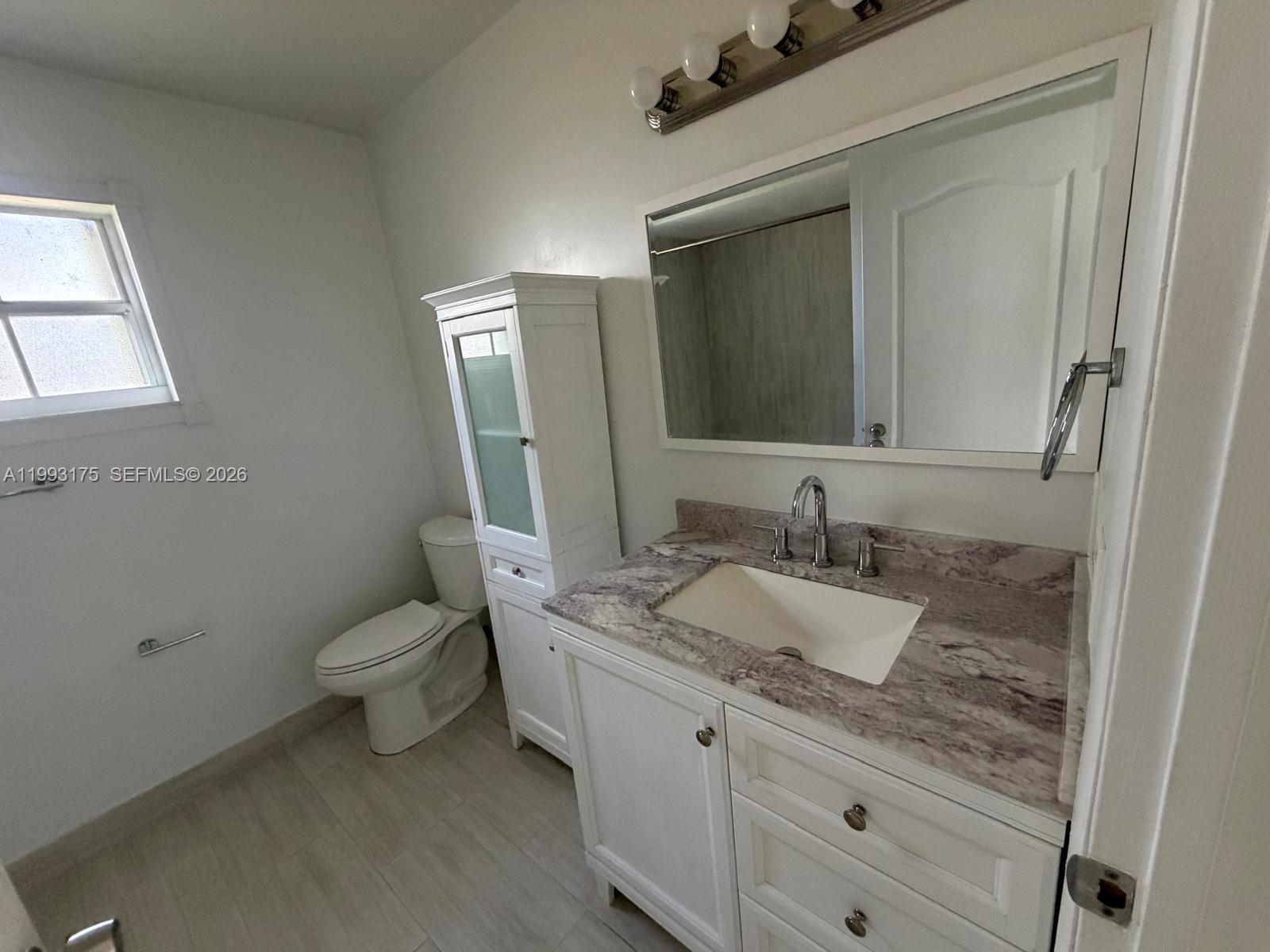 12695 Southwest 144th Terrace Miami, FL 33186 - Photo 8 of 43 a bathroom with a granite countertop toilet sink and mirror
