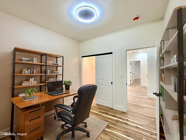 a view of a workspace with furniture and a bookshelf