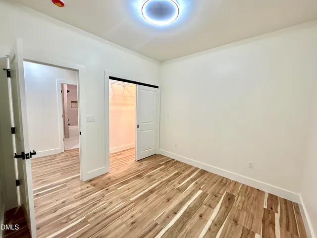 a view of a room with wooden floor and bathroom