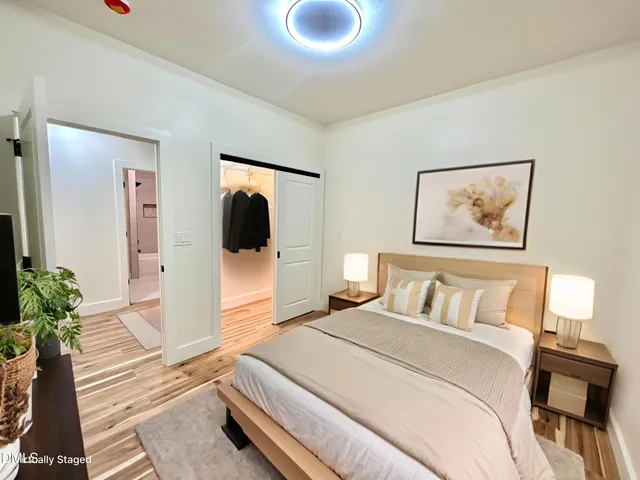 a bedroom with a bed and a potted plant