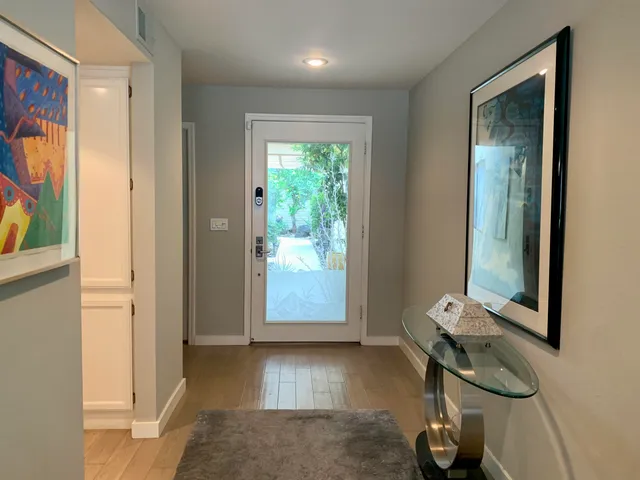 a living room with furniture kitchen view and a flat screen tv