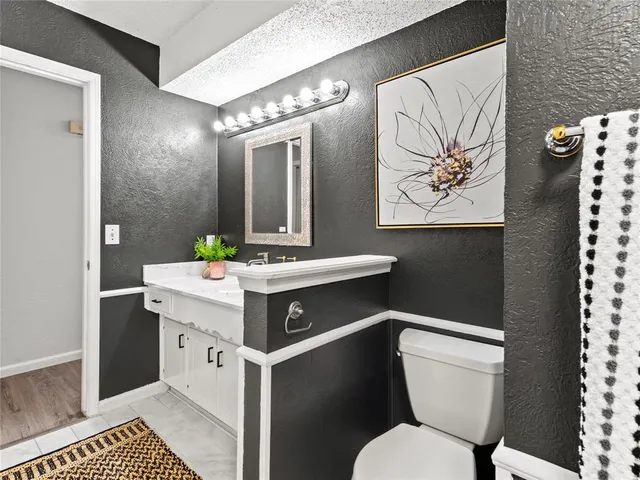 a bathroom with a sink mirror vanity and toilet