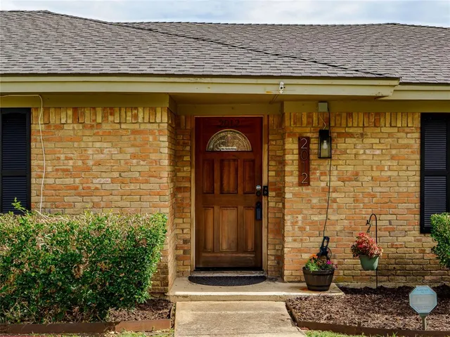 a front view of a house with a potted plant