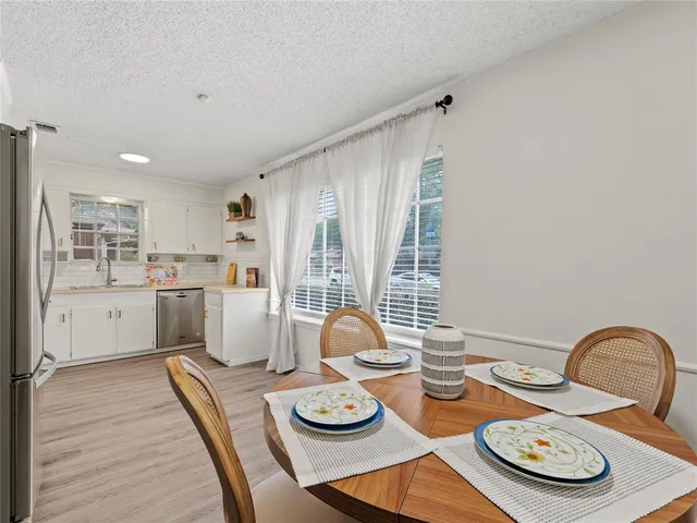 a kitchen with stainless steel appliances granite countertop a dining table and chairs