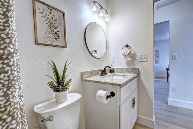 a front view of a house with a yard and large trees