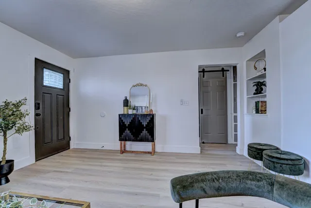 a kitchen with stainless steel appliances granite countertop a stove a sink dishwasher a dining table and chairs with wooden floor