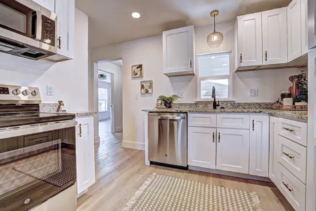 a kitchen with granite countertop lots of counter top space and living room