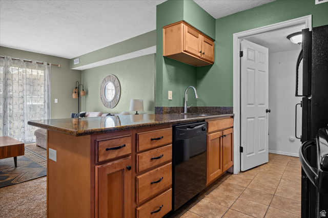 2095 South Main Street, Unit 13 Bountiful, UT 84010 - Photo 8 of 45 Kitchen featuring a peninsula, a textured ceiling, black appliances, dark stone countertops, and light tile patterned floors