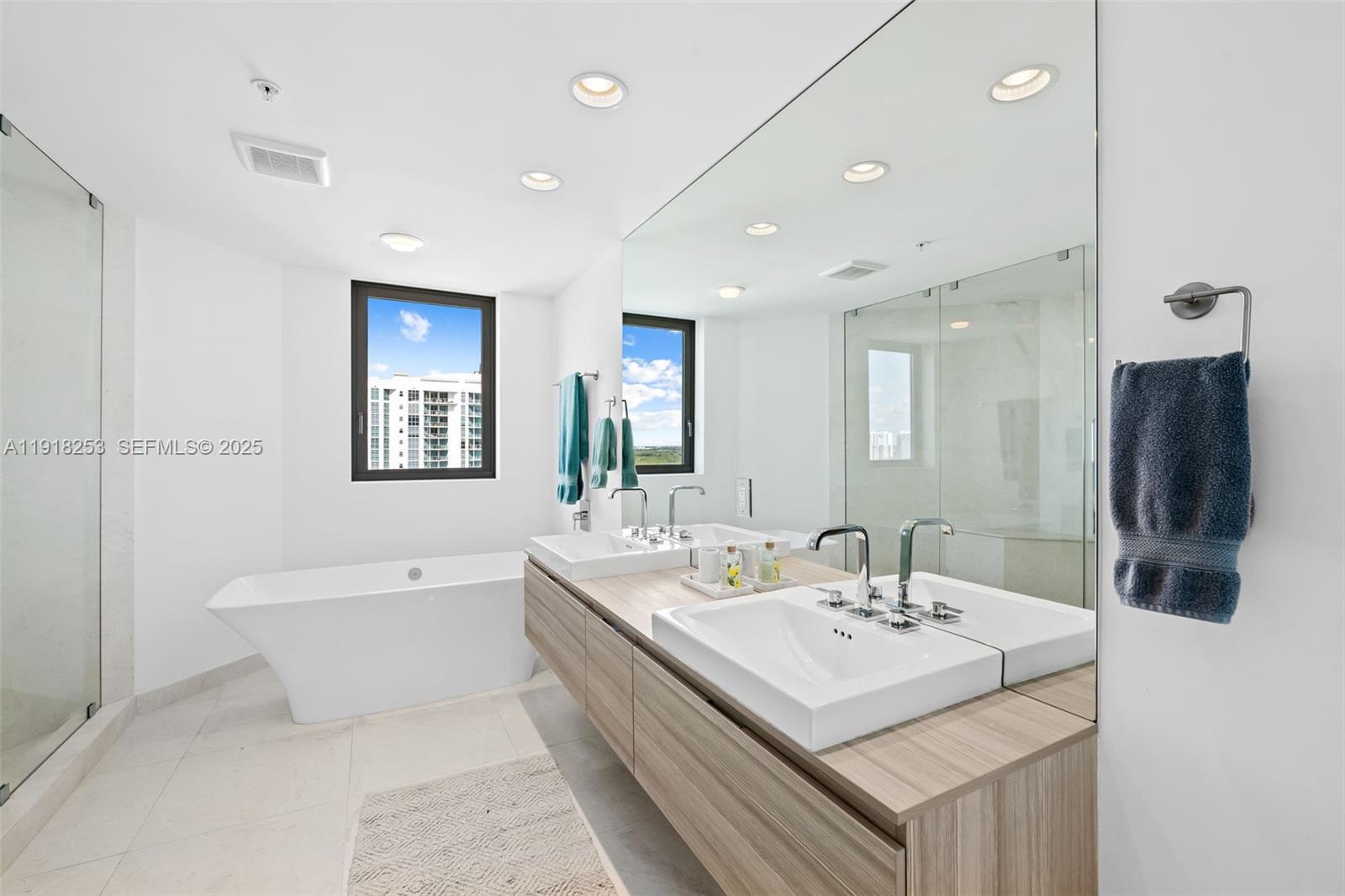 17111 Biscayne Boulevard, Unit 2103 North Miami Beach, FL 33160 - Photo 12 of 33 a en suite bathroom with a double vanity sink a mirror and a bathtub