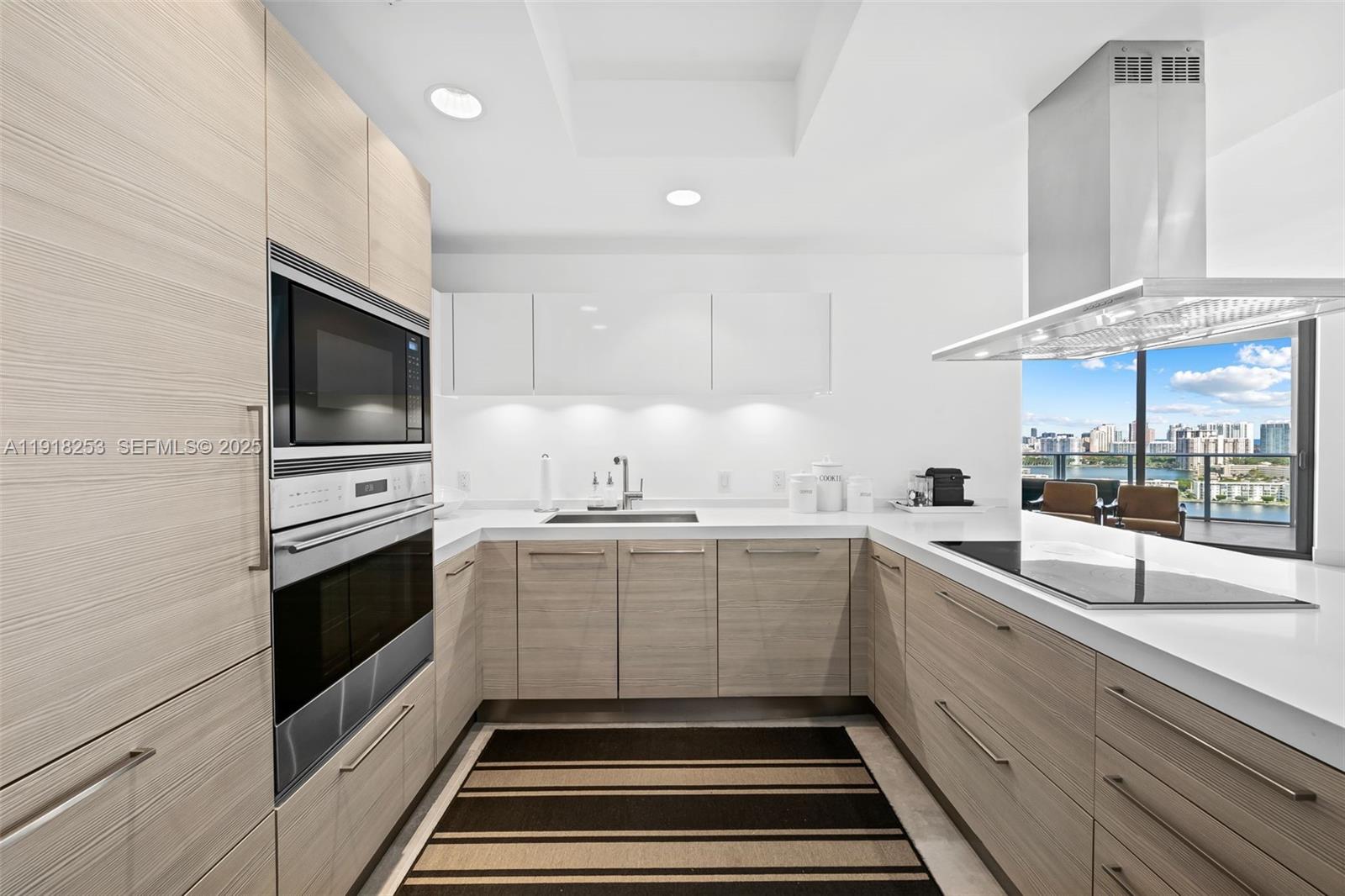 17111 Biscayne Boulevard, Unit 2103 North Miami Beach, FL 33160 - Photo 8 of 33 a kitchen with sink cabinets and microwave