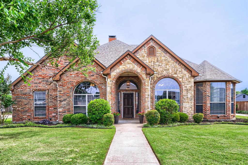 Brick and stone facade featuring arched windows and entryway
