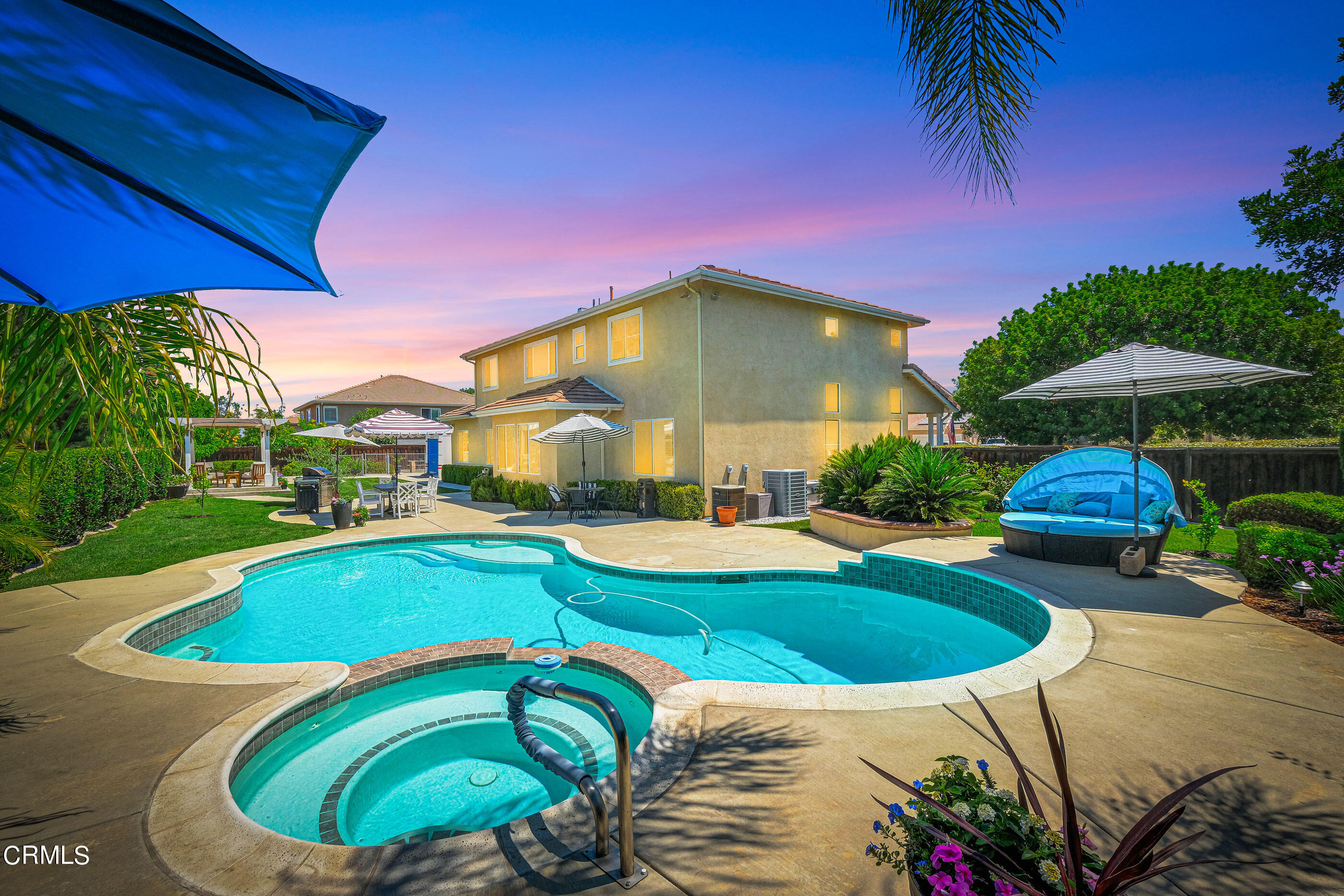 a view of a swimming pool with lawn chairs under an umbrella