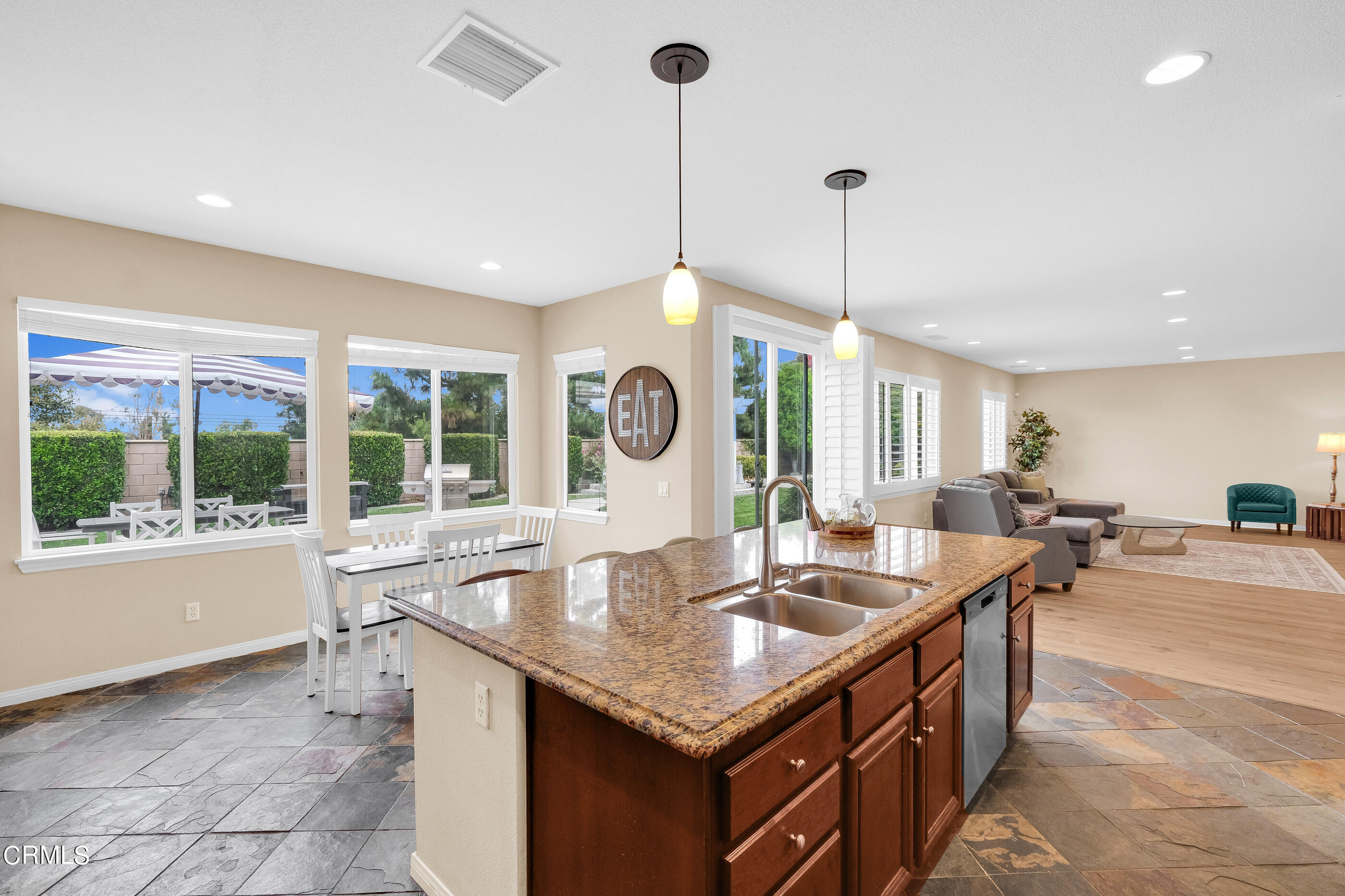8317 Carriage Court Riverside, CA 92508 - Photo 15 of 37 a kitchen with granite countertop a sink a counter top space and living room view