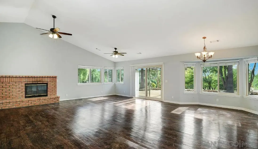 14525 Millards Ranch Lane Poway, CA 92064 - Photo 10 of 29 a view of an empty room with wooden floor fireplace and a window