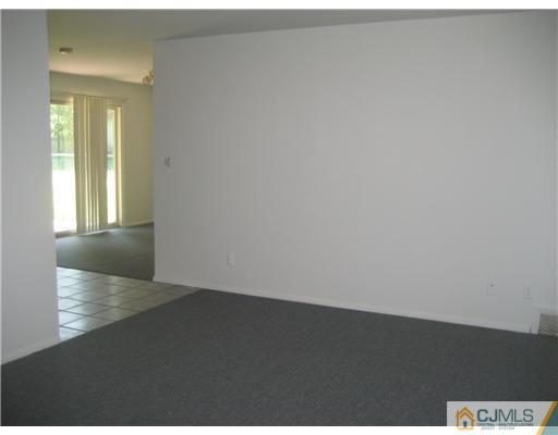 34 Idlewild Road Edison, NJ 08817 - Photo 2 of 7 an empty room with wooden floor and windows