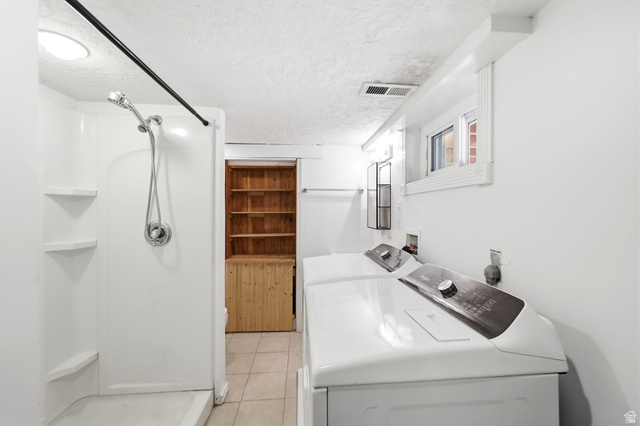 936 Chatelain Road Ogden, UT 84403 - Photo 21 of 33 Bright, functional laundry room featuring front-loading washer and dryer units, dark countertop workspace, recessed ceiling lighting, and direct access to adjacent spaces