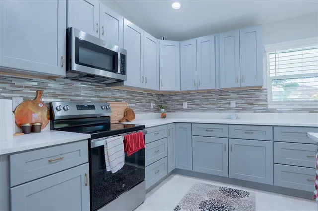 a kitchen with granite countertop stainless steel appliances white cabinets sink and dishwasher