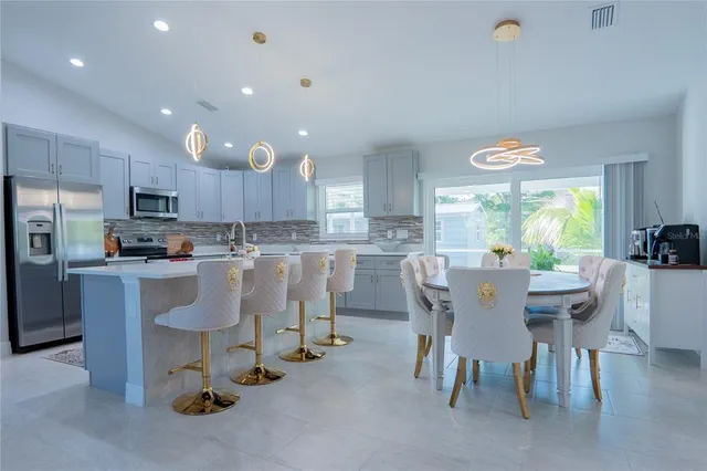 a large kitchen with dining table chairs and a refrigerator