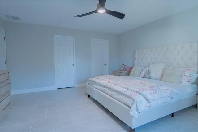 a bedroom with a bed and a ceiling fan