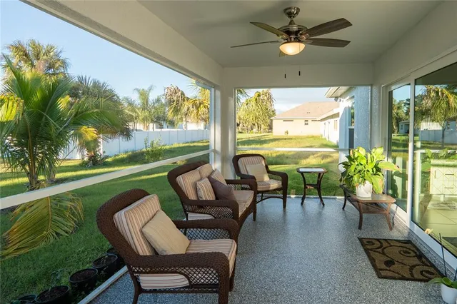 a living room with patio furniture and a floor to ceiling window