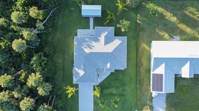 an aerial view of a house with a yard basket ball court and outdoor seating