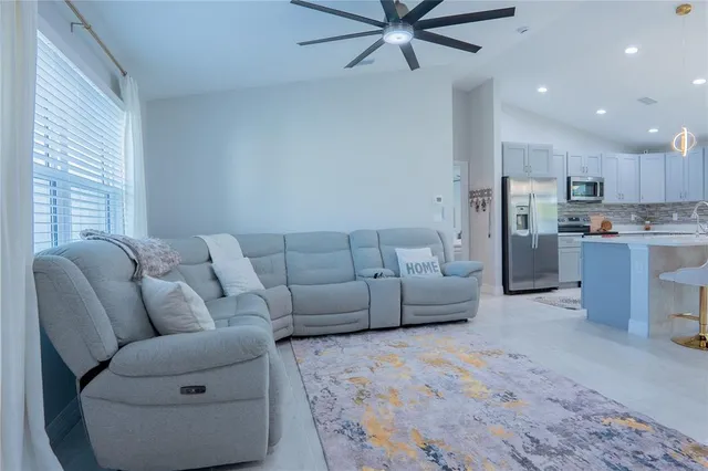 a living room with furniture and kitchen view