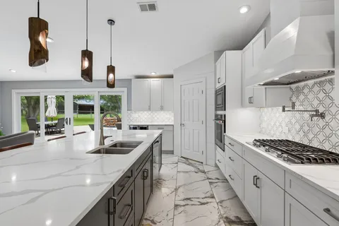 a kitchen with stainless steel appliances granite countertop a stove and a sink