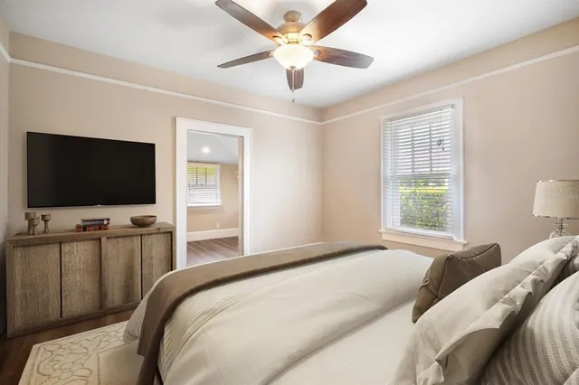 a bedroom with a bed tv and a window