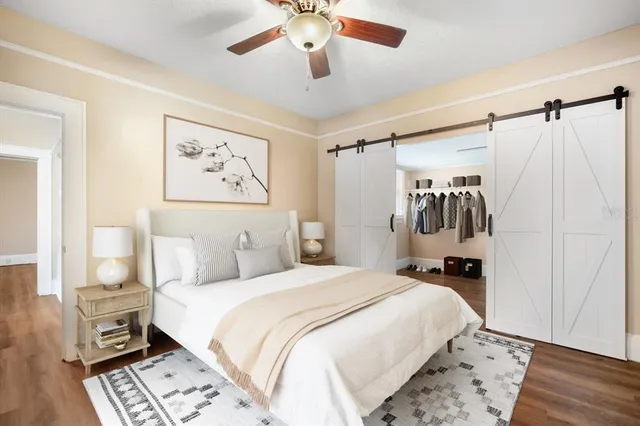 a bedroom with a large bed and a chandelier