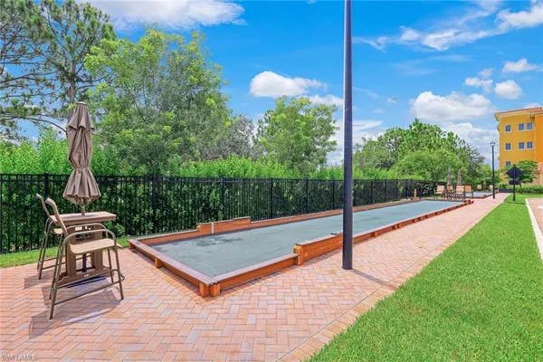 a view of a swimming pool with lawn chairs under palm trees