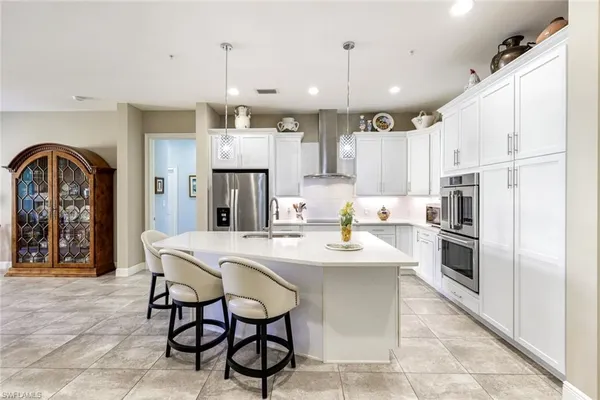 a kitchen with kitchen island granite countertop a sink a counter top space appliances and cabinets