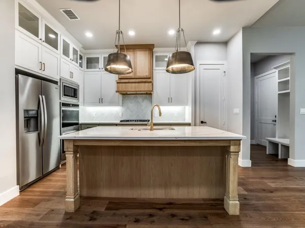 a kitchen with stainless steel appliances granite countertop a stove a refrigerator and a view of living room