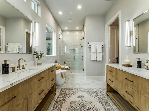 a spacious bathroom with a double vanity sink toilet mirror and bathtub