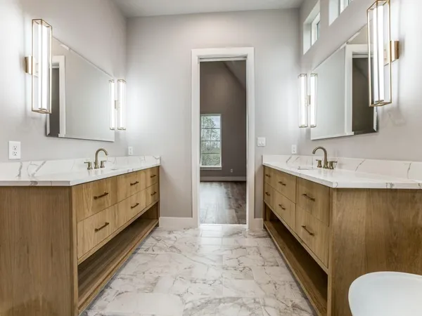 a spacious bathroom with double vanity sink a mirror and a bathtub