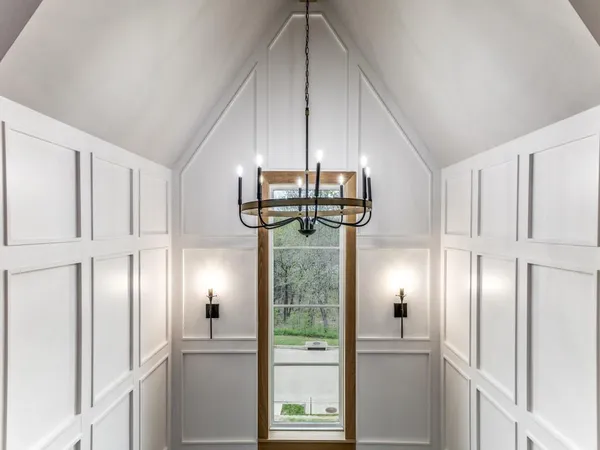 a view of a hallway with stainless steel appliances granite countertop cabinets and a window