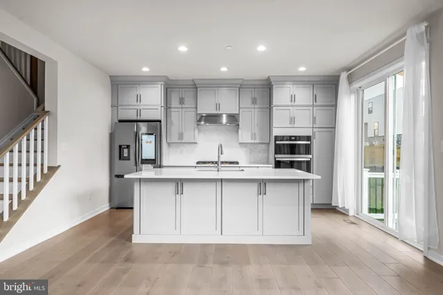 a kitchen with kitchen island sink stove and refrigerator