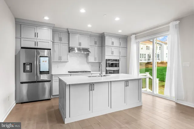 a kitchen with kitchen island white cabinets and refrigerator