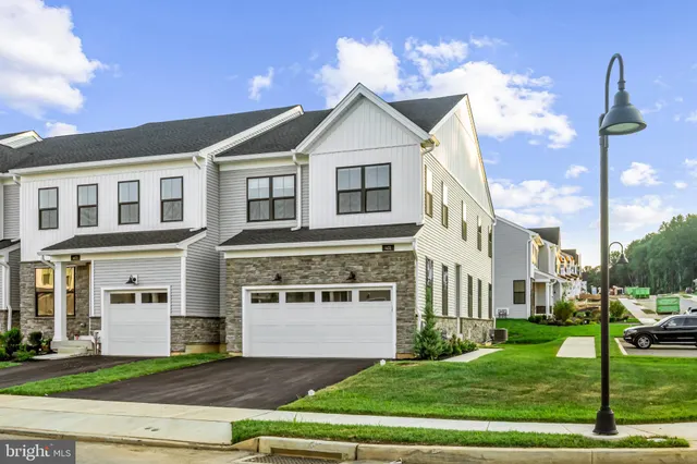 a view of a white house with a yard and large windows
