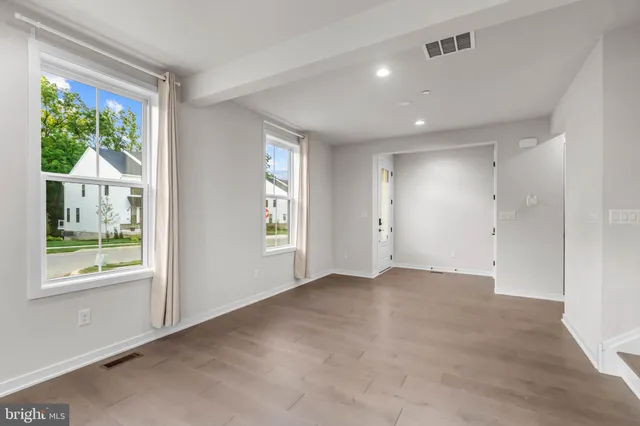 an empty room with windows and view of backyard