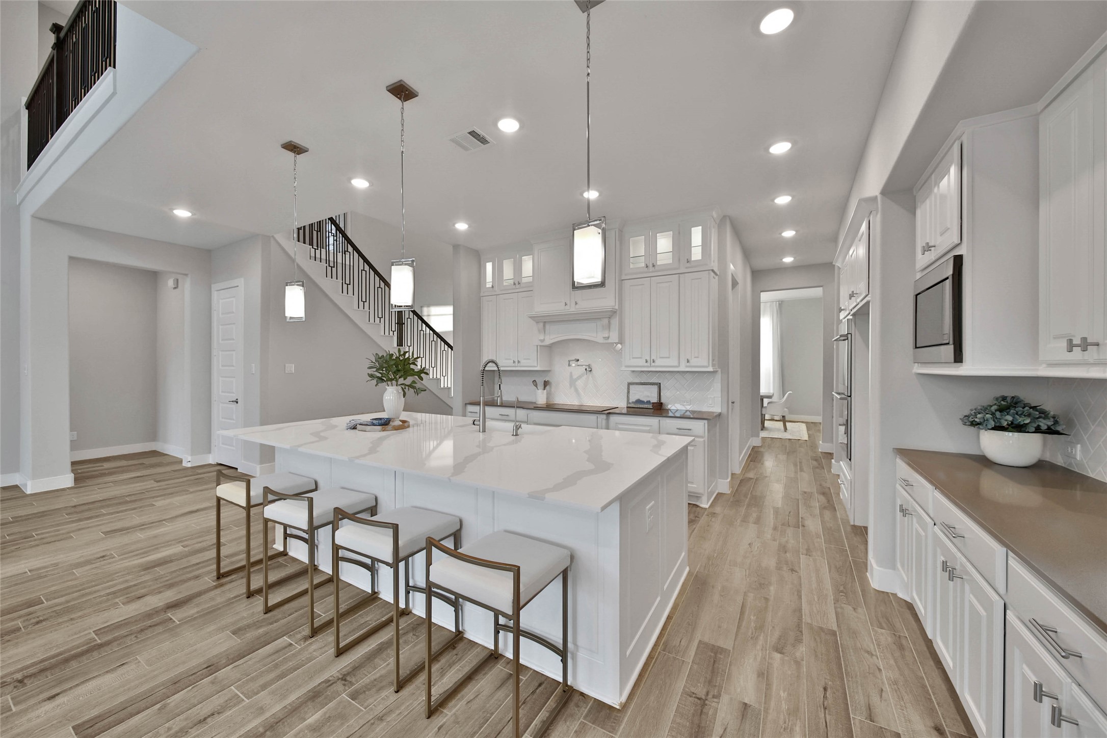 29402 Cir S Rnch Trail Fulshear, TX 77406 - Photo 12 of 50 The center island is illuminated by stylish pendant lights, adding warmth and designer appeal to the space. Large enough to host homework sessions or casual meals, it’s a true gathering spot in the home.