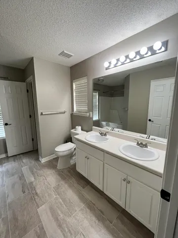 a bathroom with a double vanity sink mirror and toilet