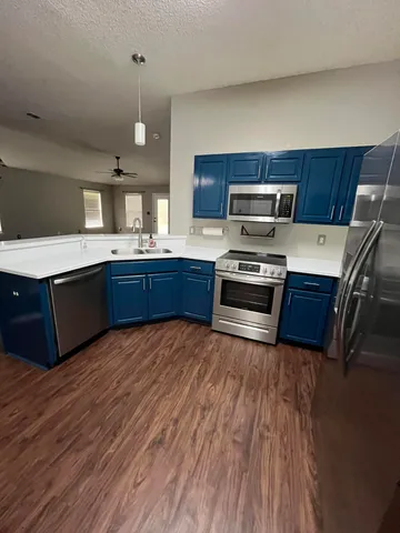 a kitchen with wooden floors and stainless steel appliances